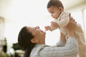 Hispanic mother smiling at baby