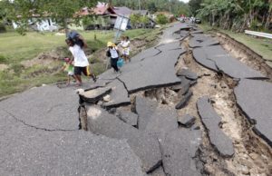 epa03095195 A Filipino family walk past a damaged national highway after  a 6.9-magnitude earthquake in Guihulngan Town, province of Negros Oriental, Central Philippines, 07 February 2012. At least 48 people were dead and up to 92 were missing after a 6.9-magnitude earthquake triggered landslides and collapsed houses in the central Philippines, an army commander said.  The missing from 06 Febraruary quake were mostly from Guihulngan City and La Libertad town in the province of Negros Oriental where landslides buried a total of almost 100 houses in two villages, army Colonel Francisco Zosimo Patrimonio said.  EPA/DENNIS M. SABANGAN