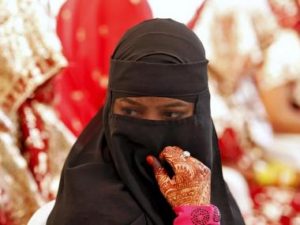 A veiled Muslim bride waits for the start of a mass marriage ceremony in Ahmedabad, India, October 11, 2015. A total of 65 Muslim couples from various parts of Ahmedabad on Sunday took wedding vows during the mass marriage ceremony organised by a Muslim voluntary organisation, organisers said. REUTERS/Amit Dave