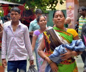 Gorakhpur: Relatives carry a child at the Baba Raghav Das Medical College Hospital where over 60 children have died over the past one week, in Gorakhpur district on Monday. PTI Photo   (PTI8_14_2017_000148B)