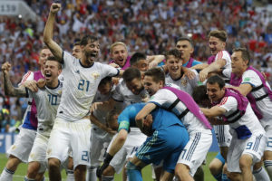 Russian players mob Russia goalkeeper Igor Akinfeev, front left in blue, after Russia defeated Spain by winning a penalty shoot in the round of 16 match between Spain and Russia at the 2018 soccer World Cup at the Luzhniki Stadium in Moscow, Russia, Sunday, July 1, 2018. (AP Photo/Manu Fernandez)