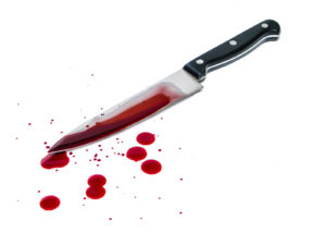 Bloody kitchen knife and blood spots on the white background