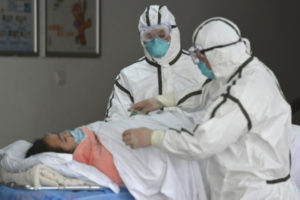 Medical workers in protective suits move a coronavirus patient into an isolation ward at the Second People's Hospital in Fuyang in central China's Anhui Province, Saturday, Feb. 1, 2020. Beijing criticized Washington's tightening of travel controls to bar most foreign nationals who visited the country within the past two weeks. (Chinatopix via AP)