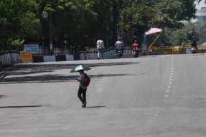 A man walks across a deserted road during a government-imposed nationwide lockdown as a preventive measure against the COVID-19 coronavirus, in New Delhi on April 12, 2020. (Photo by Sajjad  HUSSAIN / AFP)