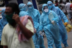 Healthcare workers wearing protective suits and face masks walk along a street in the Dharavi slum area of Mumbai, India on June 07, 2020. India continues in nationwide lockdown to control the spread of the Coronavirus (COVID-19) pandemic. (Photo by Himanshu Bhatt/NurPhoto via Getty Images)