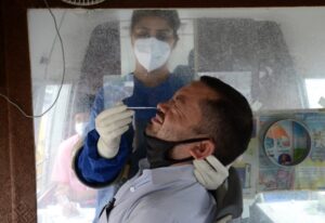 Amritsar: A health worker takes a nasal swab sample from a person for COVID-19 tests inside a mobile van, amid a surge in coronavirus cases in Amritsar on Friday, 28 May, 2021.  (Photo:Pawan sharma/IANS)