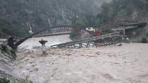 An under construction bridge is seen collapsed on a river along a national highway between Pithoragarh-Champawat, in Chalthi on October 19, 2021 following heavy rainfalls in northern India. - At least 24 people died and more than a dozen were missing after landslides and flash floods triggered by several days of heavy rain hit northern India, officials said on October 19. (Photo by AFP)