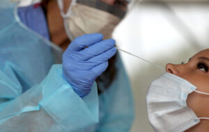 BROCKTON - AUGUST 13: A nurse practitioner administers COVID-19 tests in the parking lot at Brockton High School in Brockton, MA under a tent during the coronavirus pandemic on Aug. 13, 2020. (Photo by David L. Ryan/The Boston Globe via Getty Images)