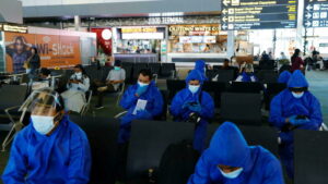 Travellers wearing protective suits are seen at the Soekarno Hatta International airport, as the country bans the arrival of travellers who have been in eight African countries to curb the spread of the new Omicron variant of the coronavirus, in Tangerang, near Jakarta, Indonesia, November 29, 2021. REUTERS/Willy Kurniawan