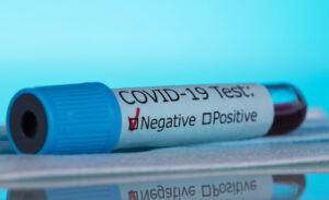 Test tube with a negative blood test for coronavirus. Macro photo on a blue background.